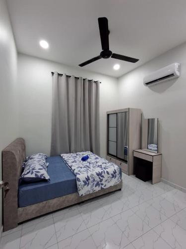 a bedroom with a bed and a ceiling fan at Dhila Homestay Jalan Pasir Mas Rantau Panjang in Pasir Mas