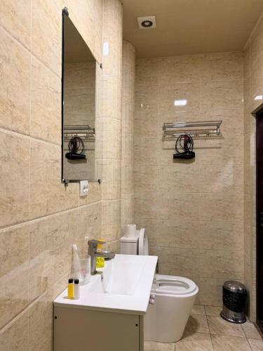 a bathroom with a white sink and a toilet at Chinor Garden Hotel - Free Airport Pick-up Yandex Go in Tashkent