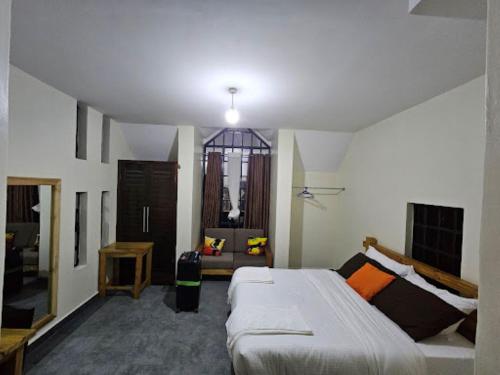a bedroom with a bed and a couch in it at Eshborns House - Near Jomo Kenyatta International Airport and SGR with shuttle services at an extra fee in Nairobi