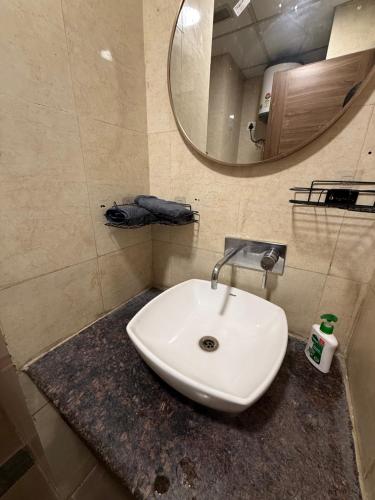 a white sink in a bathroom with a mirror at AeroNest Luxe in Zirakpur