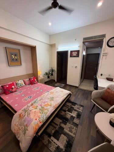 a bedroom with a large bed and a living room at AeroNest Luxe in Zirakpur