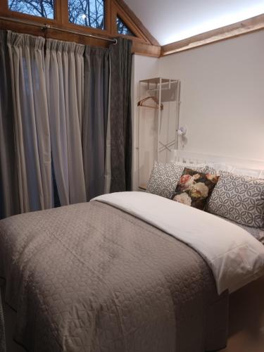 a bedroom with a bed and a window with curtains at Oak framed appartment in Chester