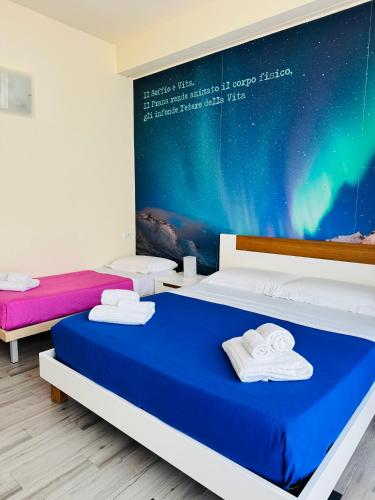 a bedroom with two beds and a poster on the wall at La Giara Guest House in Marina di Modica