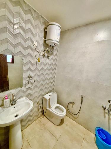 a bathroom with a toilet and a sink at Mokshika Homes at Rishikesh in Birbhaddar