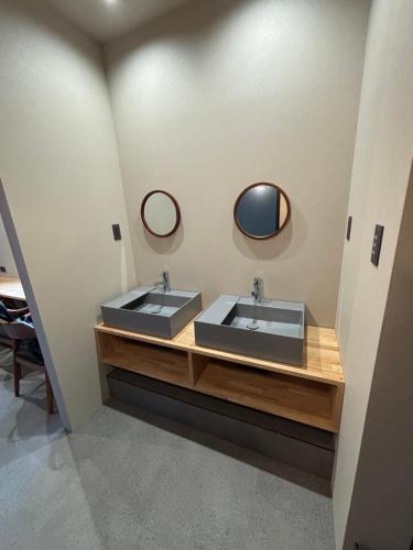 a bathroom with two sinks and two mirrors at HOTEL919Otemachi in Hiroshima