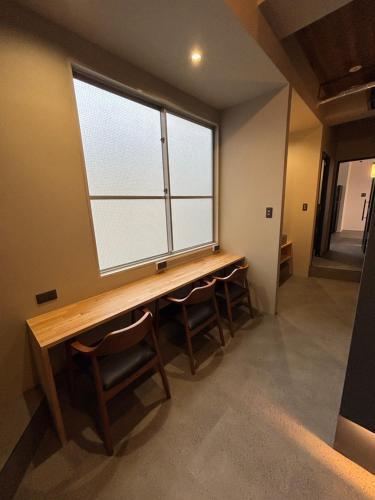 a room with a large window and a wooden table at HOTEL919Otemachi in Hiroshima