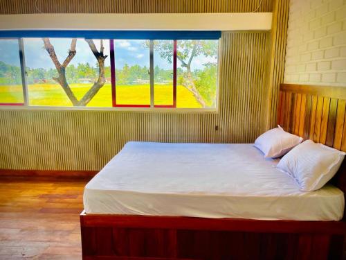 a bed in a room with a large window at Green Crown Villa in Polonnaruwa