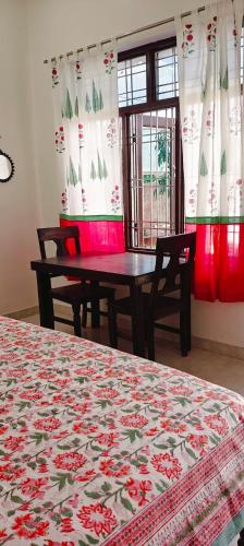 a dining room with a table and chairs and curtains at Tara pushkar in Pushkar