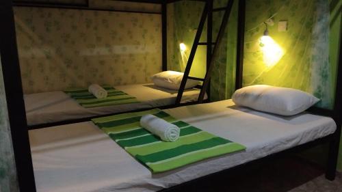 two bunk beds with towels and pillows on them at Hiranya Mountain View Hostel Kandy in Kandy