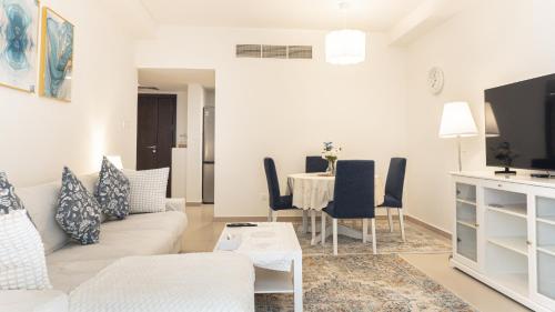 a living room with a couch and a table at Elegant 1BHK Apartment with Courtyard View in Pacific Al Marjan Island in Ras al Khaimah