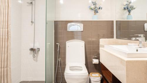 a bathroom with a shower and a toilet and a sink at Elegant 1BHK Apartment with Courtyard View in Pacific Al Marjan Island in Ras al Khaimah