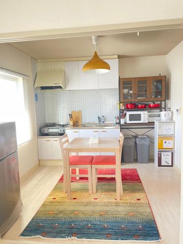 a kitchen with a wooden table and a dining room at 江の島HOUSE Comfortable & Relaxing Stay in Fujisawa