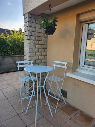 a table and two chairs sitting on a patio at Maison grande terrasse Poligny in Poligny