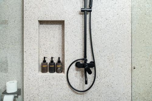 a shower with two bottles of alcohol on a wall at Mount Valley Inn in Kubupenlokan