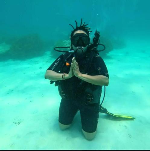 a person in a diver suit standing in the water at Wasini dolphin adventure in Shimoni