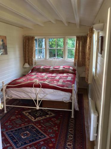 Dormitorio pequeño con cama y alfombra en Stourbank Cottage, en Nayland