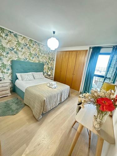 a bedroom with a bed and a table with a vase of flowers at Marin Beach Apartments Patacona in Valencia