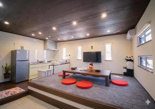 a kitchen with a table and red stools at 天然温泉付別荘Green House in Shirahama