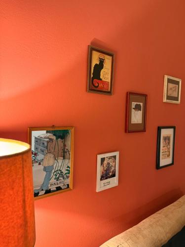a bedroom with orange walls with pictures on the wall at Boho ElTha Lotus in Patra