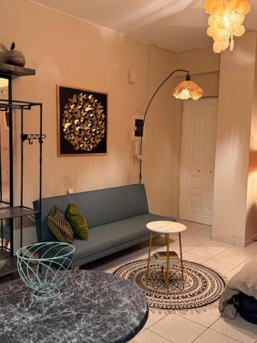 a living room with a blue couch and a table at Boho ElTha Lotus in Patra