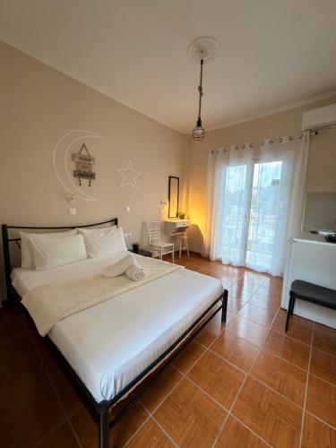 a bedroom with a large white bed and a table at Elenas Garden in Kavos