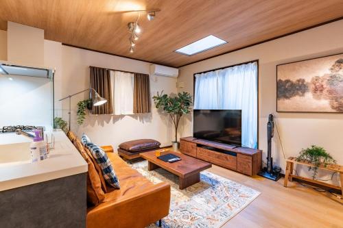 a living room with a couch and a flat screen tv at NIKYO Senzo Villa Private Villa OSAKA in Osaka
