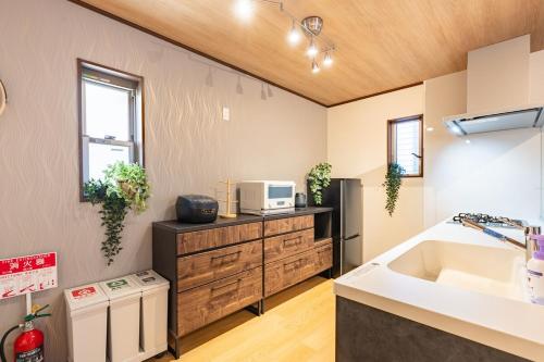 a kitchen with a sink and a microwave on a counter at NIKYO Senzo Villa Private Villa OSAKA in Osaka