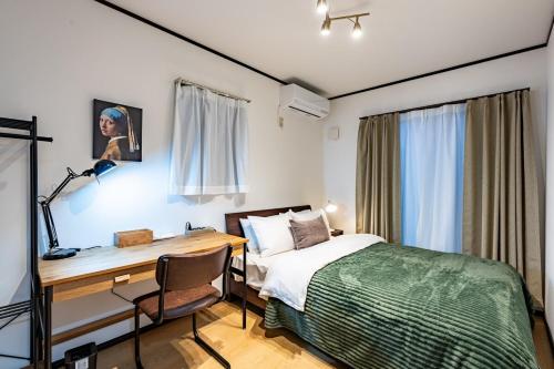 a bedroom with a desk and a bed and a desk and a desk at NIKYO Senzo Villa Private Villa OSAKA in Osaka