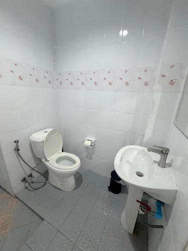 a white bathroom with a toilet and a sink at KataKeet in Kata Beach
