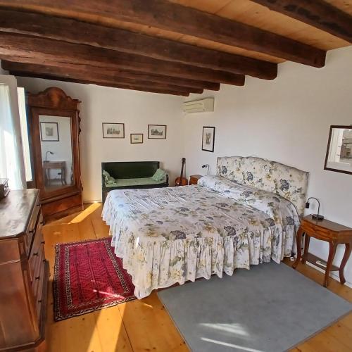 a bedroom with a bed in a room with wooden floors at Mandre-Chiggiato, Sesta Presa in Ca Corniani