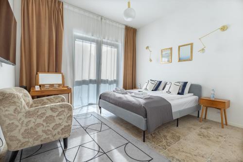 a bedroom with a bed and a chair at Baltivia Haus II in Gdynia