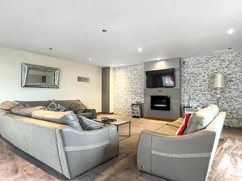 a living room with two couches and a tv at The Wendover in Rowen