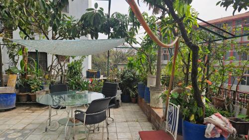 a patio with a table and chairs and potted plants at Kompass Sky Garden Home in Dhaka