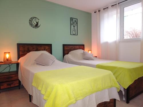 een slaapkamer met twee bedden met gele lakens bij La Pardigone in Castellane