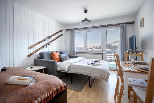 a living room with a bed and a couch and a table at Le Tracouet - Central et cosy studio in Nendaz