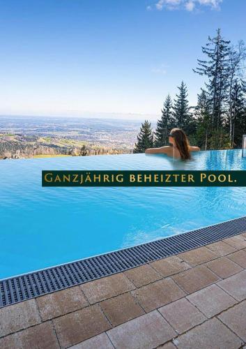 a woman is sitting in a swimming pool at Schilcherland Chalet Südsteiermark in Trahütten