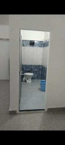 an open door to a bathroom with a toilet at Akshay Hotel in Bikaner