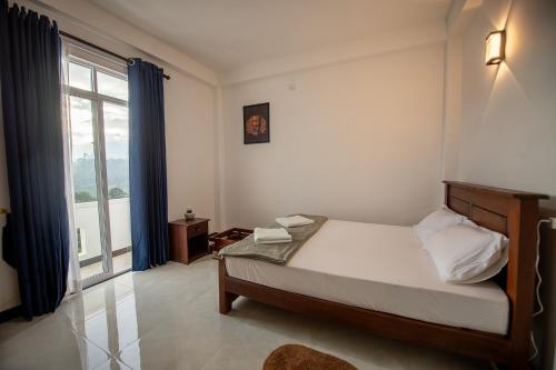 a bedroom with a bed and a large window at Green Infinity Resorts in Diyatalawa