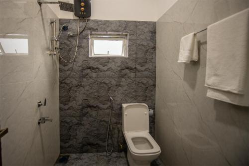 a bathroom with a toilet and a window at Green Infinity Resorts in Diyatalawa