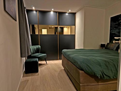 a bedroom with a green bed and a chair at GuestHouse Groenplaats in Antwerp