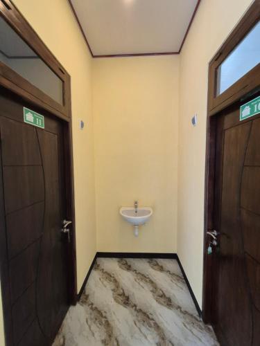 a bathroom with two doors and a sink at d'Alvin Homestay 2 in Labuan Bajo