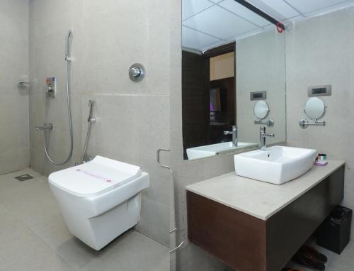 a bathroom with a toilet and a sink and a shower at Veronica Hotel in Vadodara