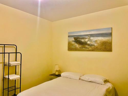 a bedroom with a bed and a picture of a boat at Babo Bolton room en suite in Farnworth