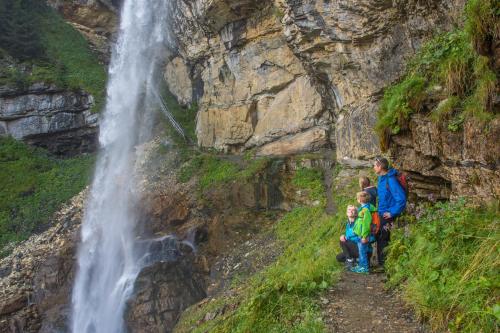 a man and two children standing next to a waterfall at Landhaus Tripolt in Radstadt