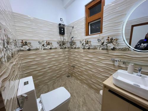 a bathroom with a sink and a toilet and a mirror at Lethi Family Villa in Negombo