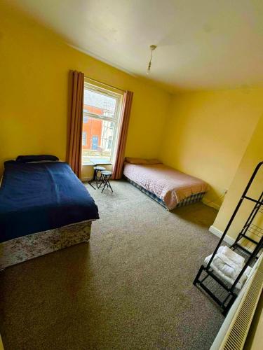 a bedroom with two beds and a window at Babo room in Farnworth
