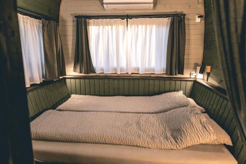 ein Schlafzimmer mit zwei Betten und einem Fenster in der Unterkunft Lakeside Sunset in Alūksne
