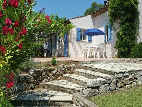 een tuin met een stenen pad en een blauwe paraplu bij Modern Villa With Swimming Pool in Salernes France in Salernes