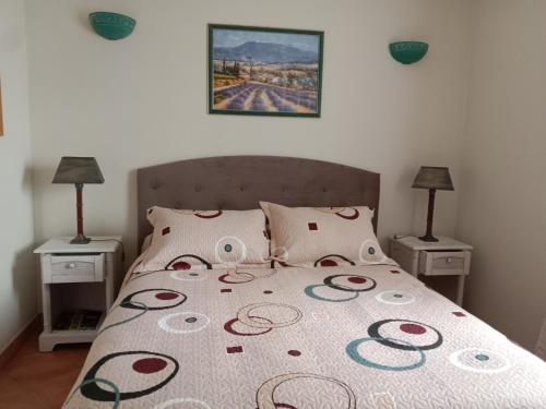 a bed in a bedroom with two night stands and two lamps at Maison des pruniers in Furiani
