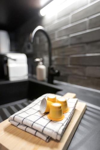 a kitchen counter with two yellow dishes and a sink at Le Cleuson - centré avec vue in Nendaz